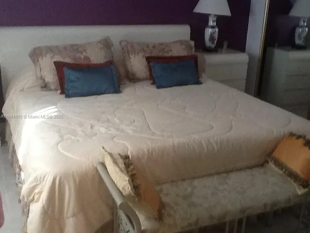 a bed sitting in a bedroom next to a lamp