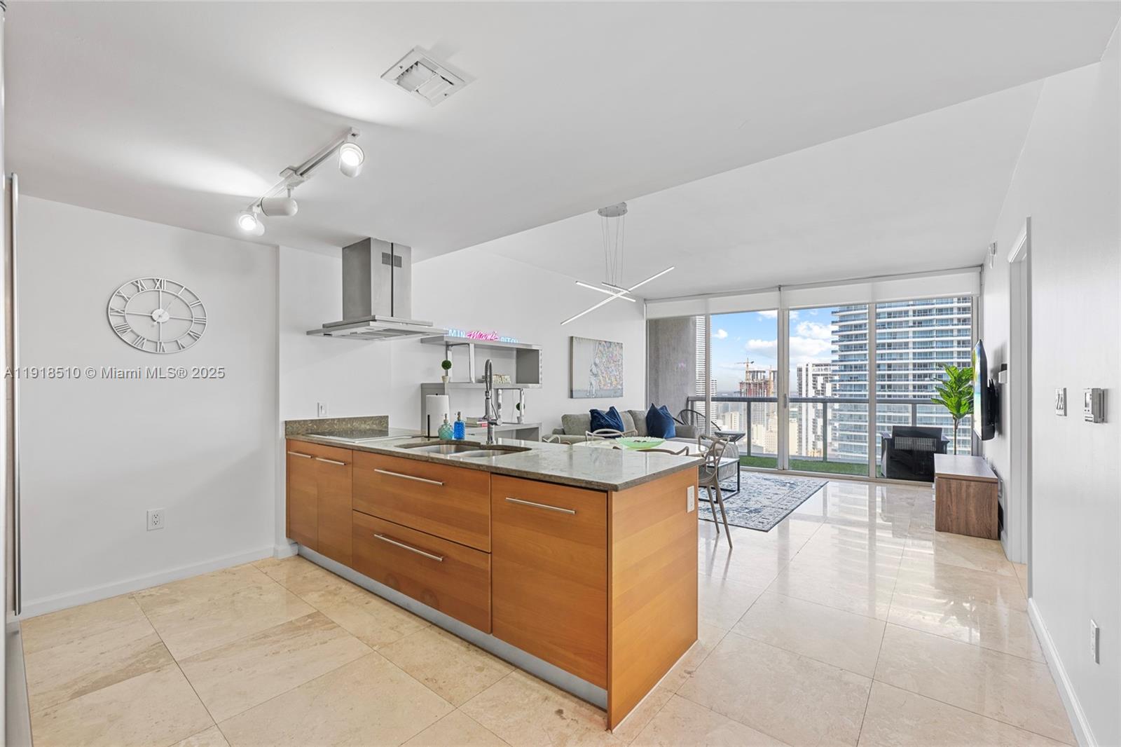 485 Brickell Avenue, Unit 3503 Miami, FL 33131 - Photo 2 of 23 a view of a kitchen with kitchen island a large window cabinets a sink and stainless steel appliances