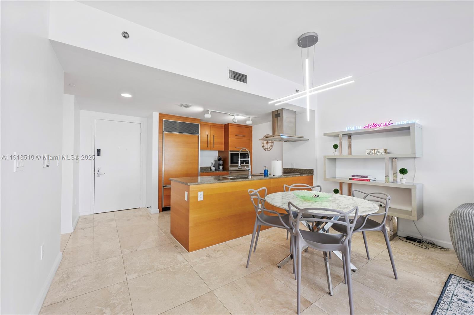 485 Brickell Avenue, Unit 3503 Miami, FL 33131 - Photo 10 of 23 a view of kitchen with kitchen island stainless steel appliances refrigerator stove dining table and chairs