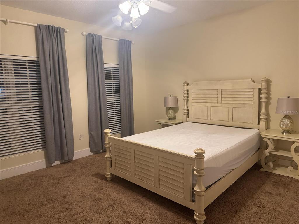 300 State Street East, Unit 206 Oldsmar, FL 34677 - Photo 12 of 23 a bed sitting in a bedroom next to a window and a chandelier