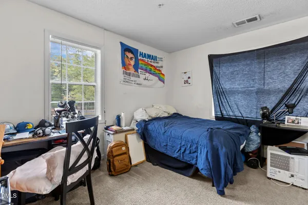 a bedroom with a bed and a window