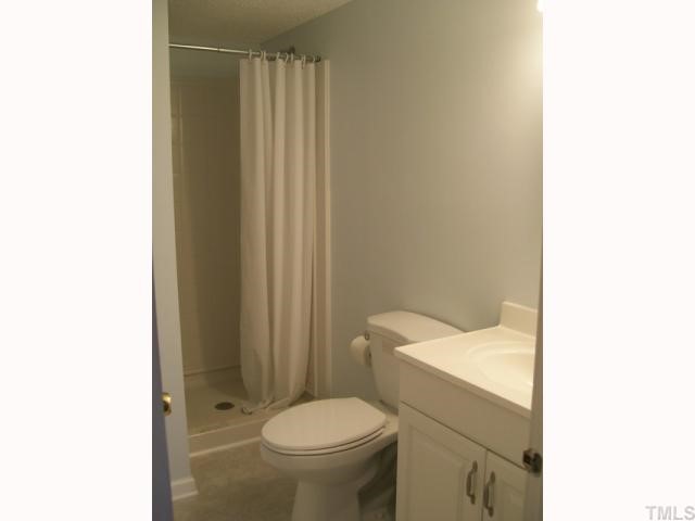 7512 Mine Shaft Road Raleigh, NC 27615 - Photo 10 of 12 a white toilet sitting next to a shower curtain