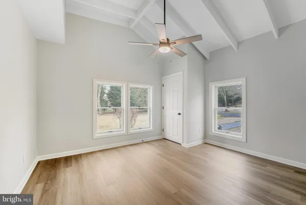 a view of an empty room with wooden floor