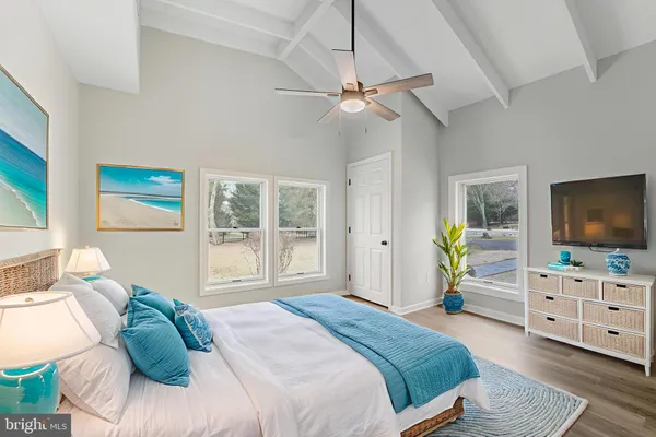 a bedroom with a bed and a flat tv screen on dresser