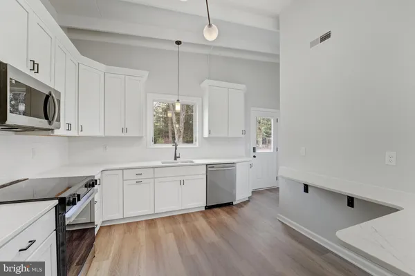 a kitchen with cabinets stainless steel appliances and window