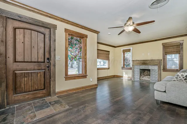 a view of a livingroom with furniture fireplace and windows