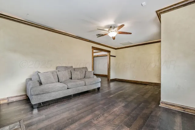 a living room with furniture and a ceiling fan