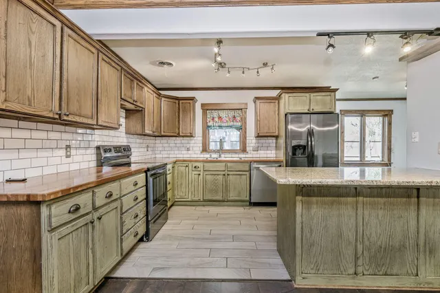 a kitchen with stainless steel appliances granite countertop a sink and cabinets