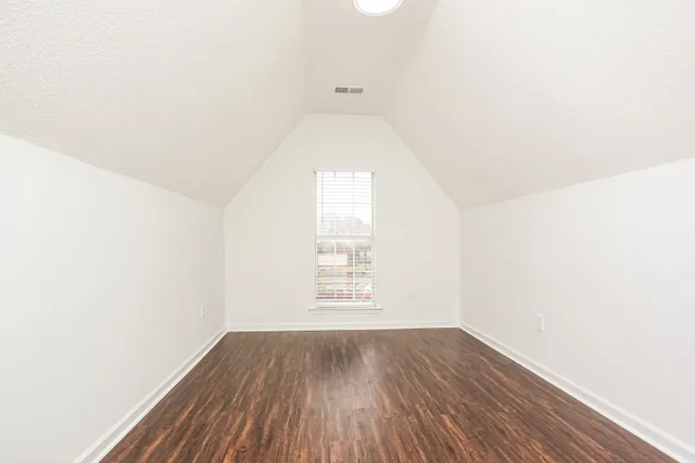 a view of a hallway with wooden floor and a window
