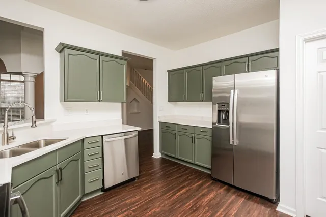 a kitchen with stainless steel appliances granite countertop a refrigerator and a sink