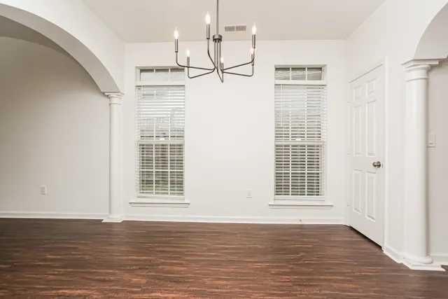 a view of empty room with wooden floor and window