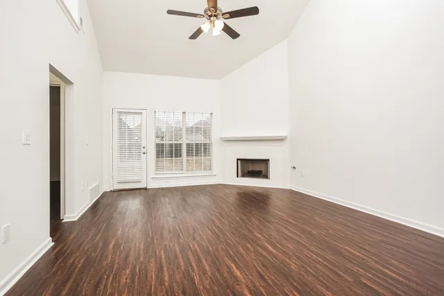 a view of a livingroom with wooden floor and a ceiling fan