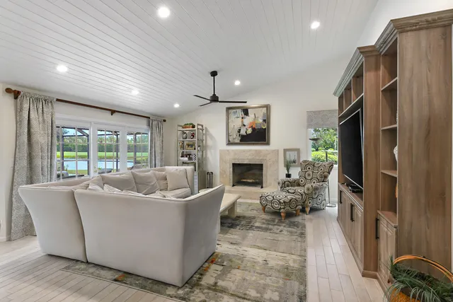 a living room with furniture a large window and a fireplace