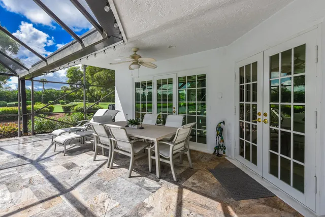a view of a patio with table and chairs under an umbrella