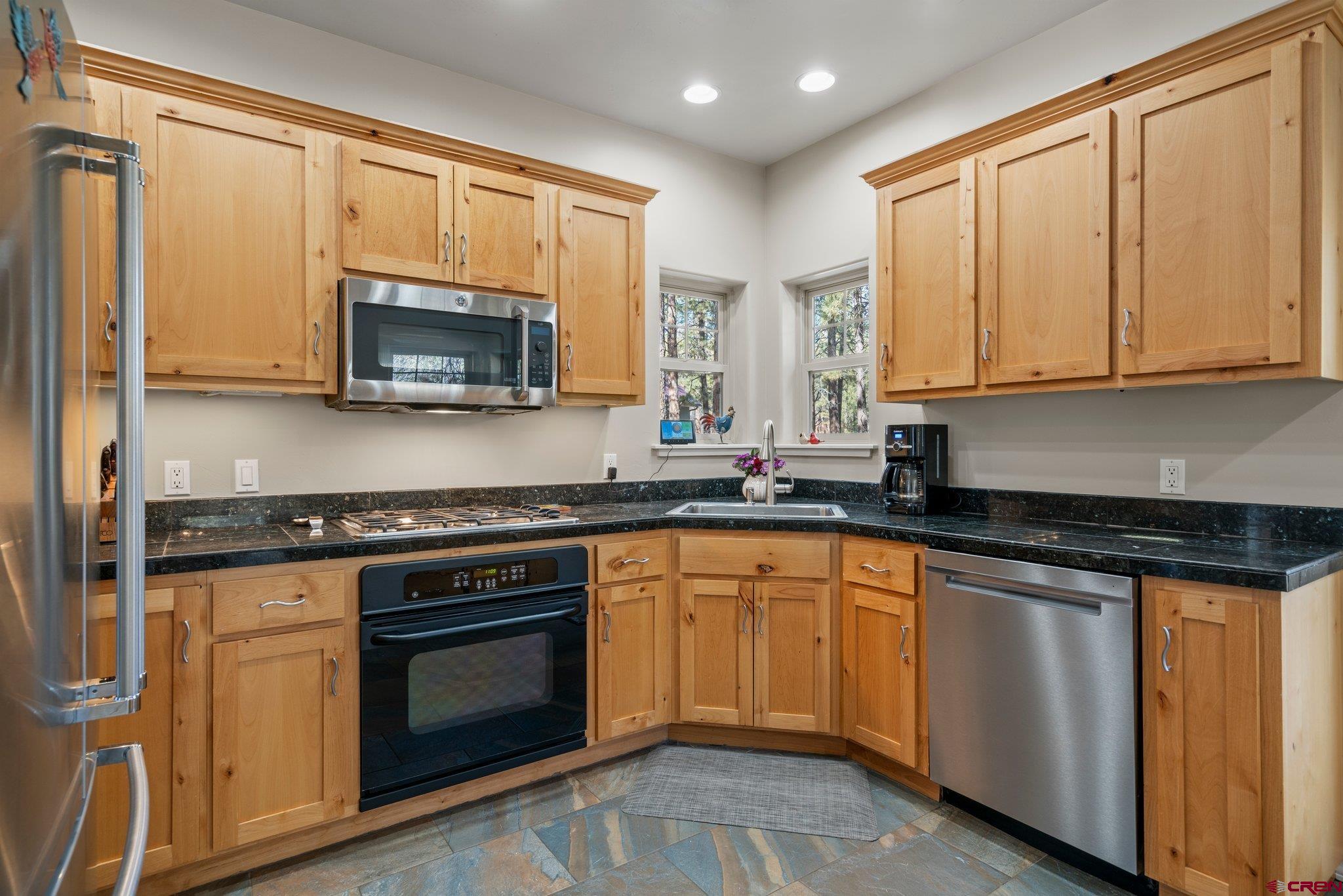 6072 County Road 240 Durango, CO 81301 - Photo 8 of 35 a kitchen with stainless steel appliances granite countertop a stove a sink and a microwave