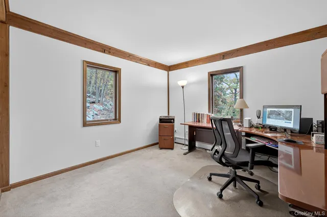 a view of a workspace with furniture and a window