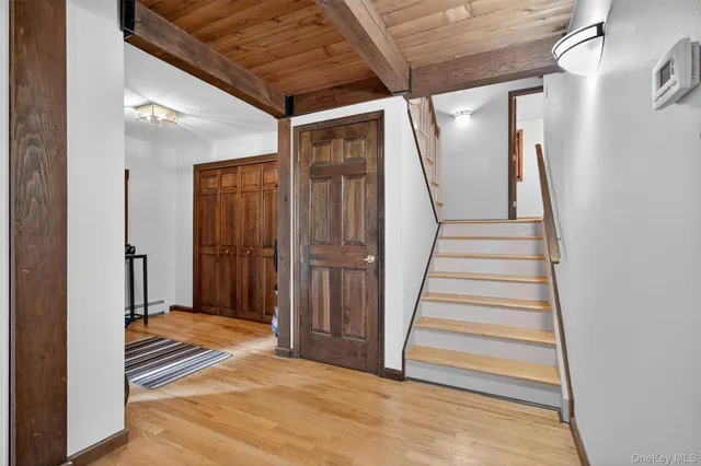 a view of a hallway with wooden floor and entryway