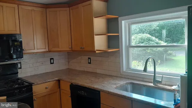 a kitchen with a sink a window and cabinets