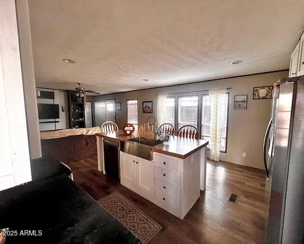 a very nice looking open kitchen with stainless steel appliances granite countertop a stove top oven a sink and a refrigerator