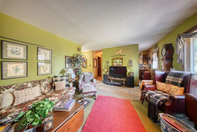 a living room with fireplace furniture and a large window