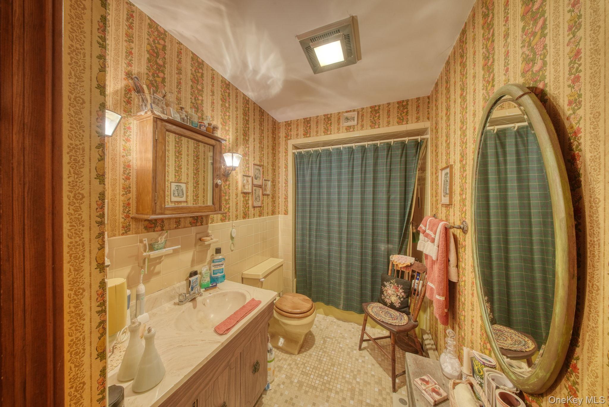 128 Hall Road Grahamsville, NY 12740 - Photo 19 of 34 Bathroom with light tile patterned floors, vanity, wallpapered walls, tile walls, and a shower with curtain