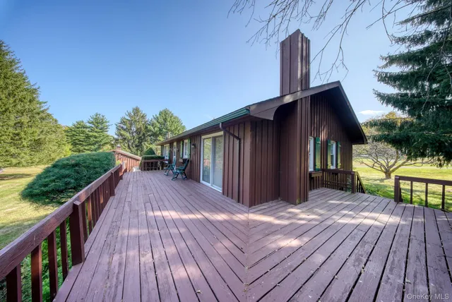 a view of a house with backyard and deck