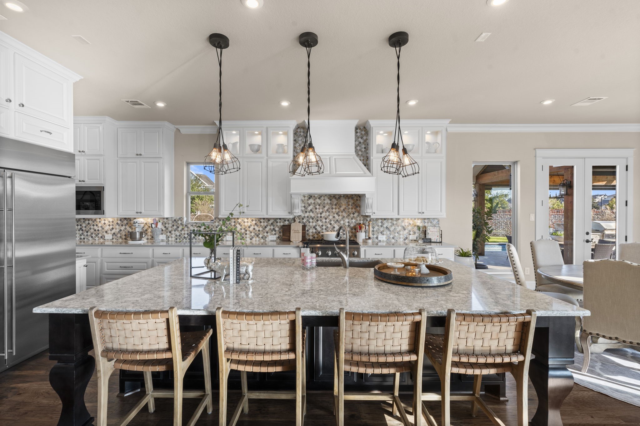 2203 Flameleaf Court Conroe, TX 77384 - Photo 15 of 49 a kitchen with stainless steel appliances kitchen island granite countertop a dining table chairs and white cabinets