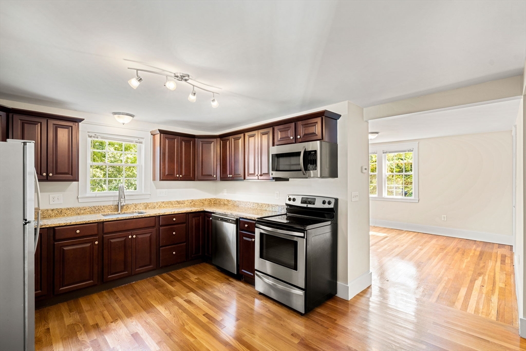 12 Chestnut Street Danvers, MA 01923 - Photo 31 of 37 a kitchen with stainless steel appliances granite countertop a stove a sink and a microwave