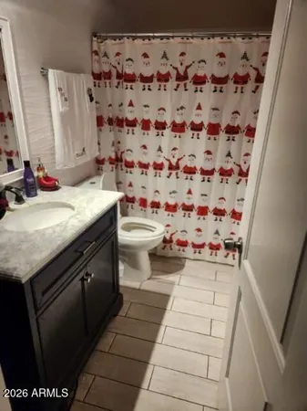 a bathroom with a granite countertop sink and a toilet