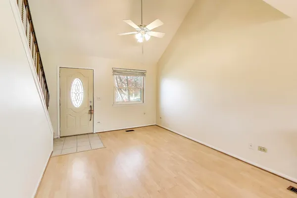 an empty room with windows and fan