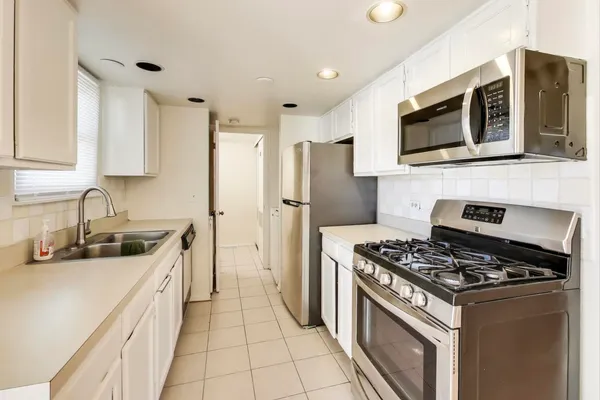 a kitchen with stainless steel appliances a stove a sink and a microwave
