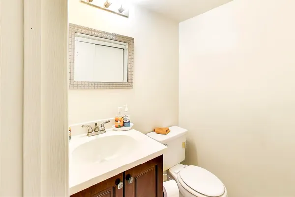 a bathroom with a sink a toilet and a mirror