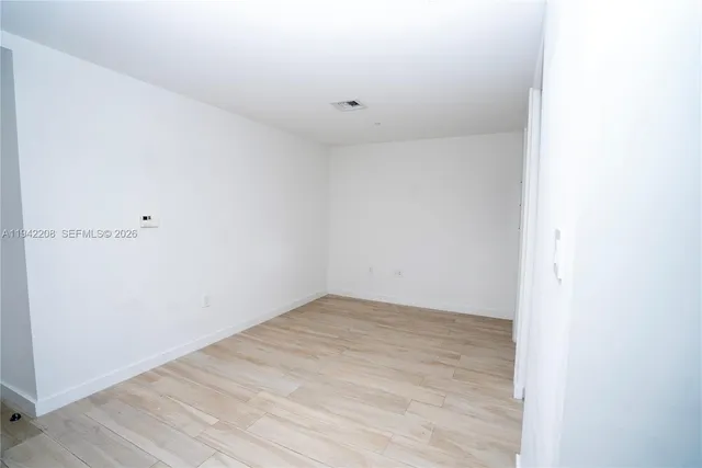 a kitchen with a wooden floor and white cabinets