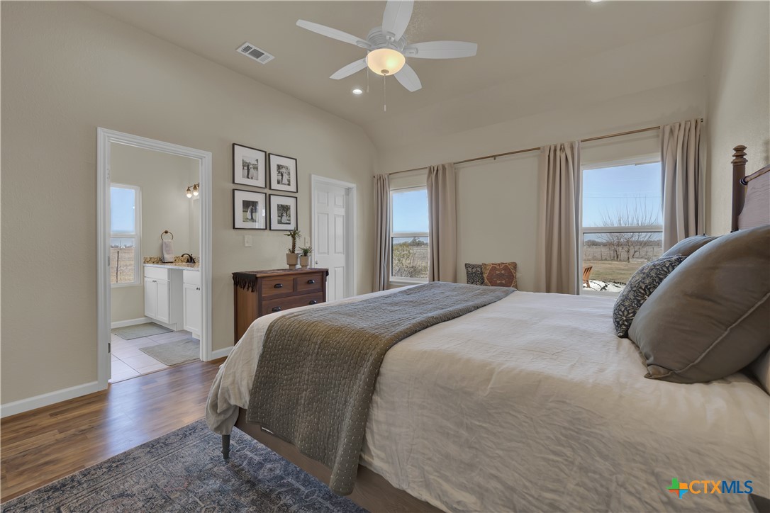 162 Friedens Church Road Seguin, TX 78155 - Photo 12 of 33 a spacious bedroom with a bed and a chandelier