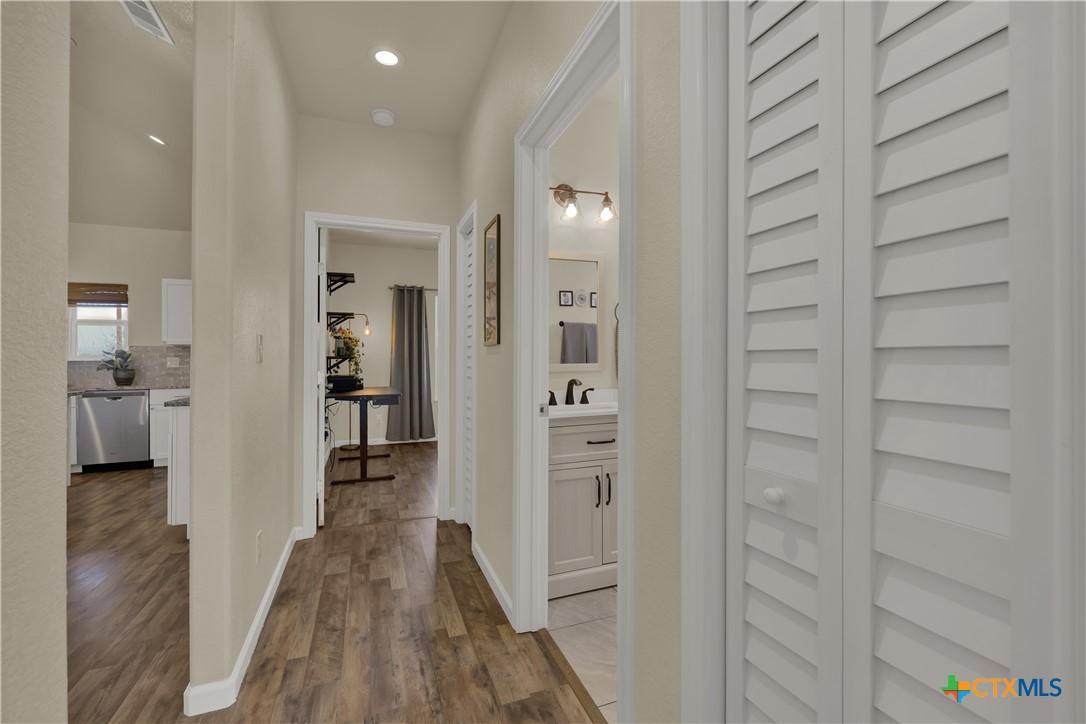162 Friedens Church Road Seguin, TX 78155 - Photo 15 of 33 a view of a hallway with wooden floor and a bathroom