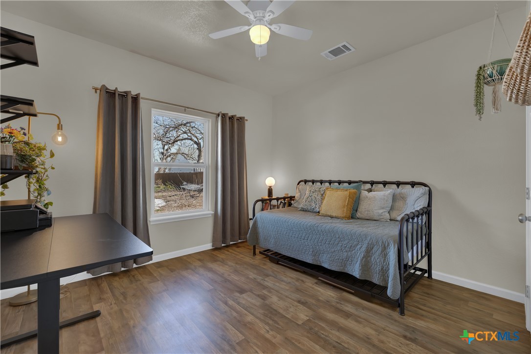 162 Friedens Church Road Seguin, TX 78155 - Photo 16 of 33 a spacious bedroom with a bed and wooden floor