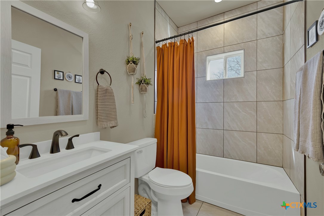 162 Friedens Church Road Seguin, TX 78155 - Photo 18 of 33 a bathroom with a sink a toilet a mirror a bathtub and shower