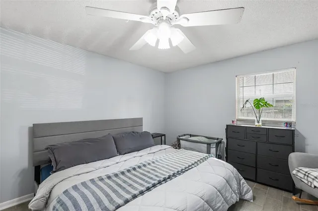 a bedroom with a bed a dresser and a chandelier