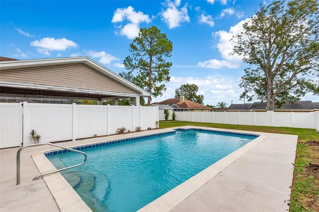 a view of a backyard with swimming pool