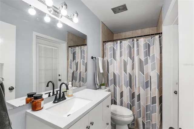 a bathroom with a sink a toilet and a large mirror