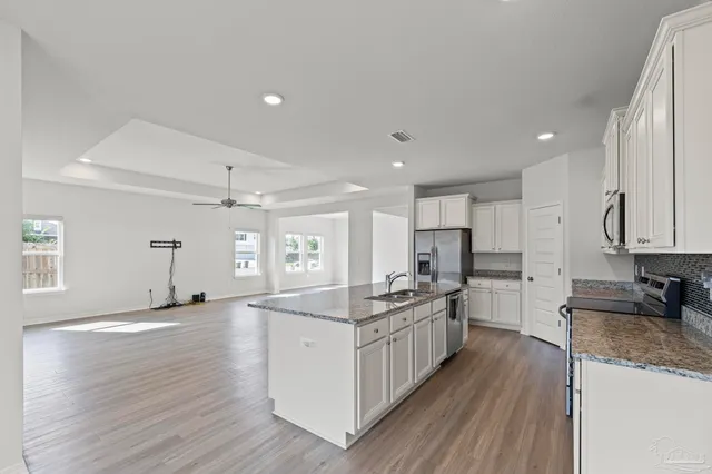 a kitchen with stainless steel appliances granite countertop a sink stove and refrigerator