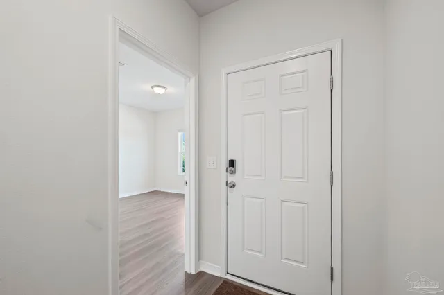 a view of an empty room with wooden floor
