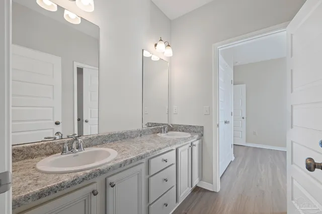 an empty room with wooden floor closet and windows