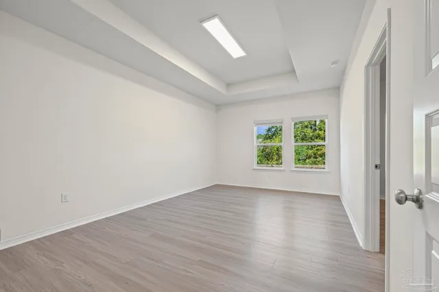 a view of a big house with a big yard and large trees
