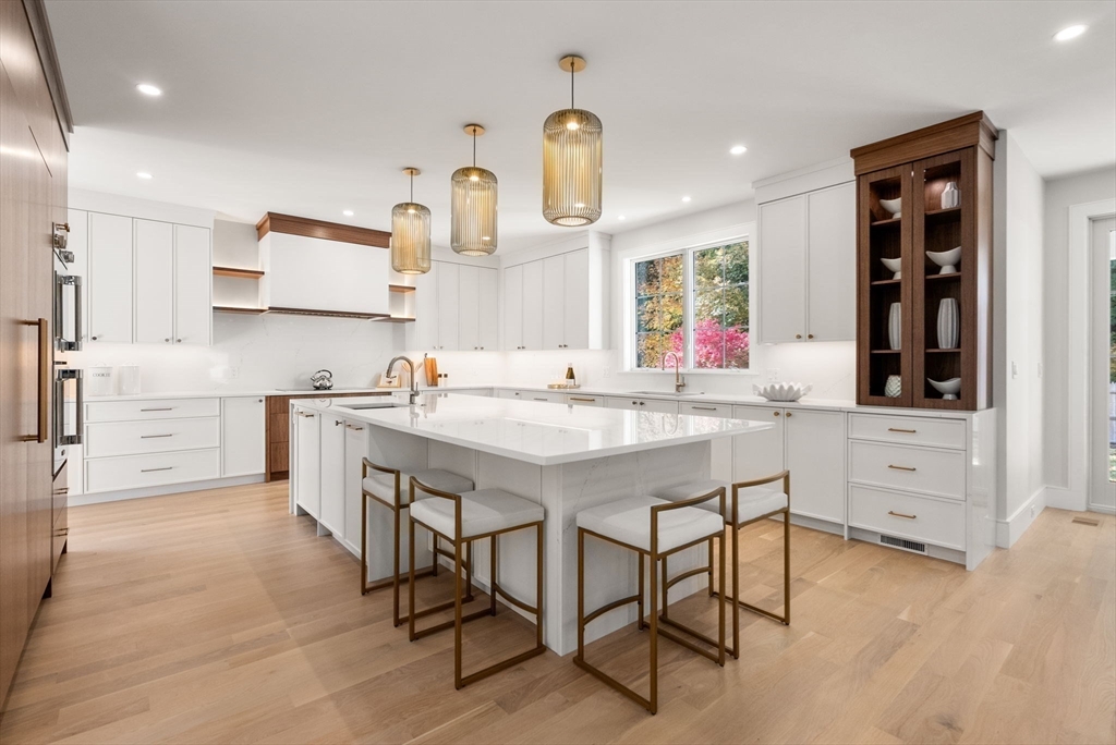 a kitchen with stainless steel appliances kitchen island granite countertop a stove a sink and a refrigerator