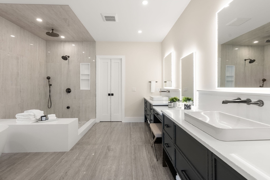 181 Wiswall Road Newton, MA 02459 - Photo 21 of 35 a bathroom with a double vanity sink a mirror and a bathtub