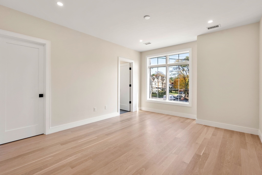 181 Wiswall Road Newton, MA 02459 - Photo 23 of 35 a view of an empty room with wooden floor and a window