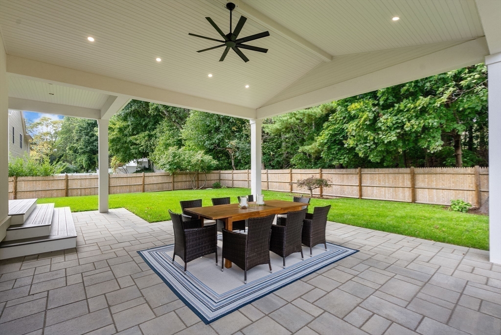 181 Wiswall Road Newton, MA 02459 - Photo 30 of 35 a view of a patio with a dining table and chairs with a floor to ceiling window