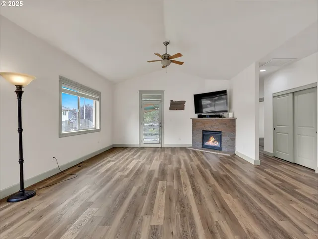 wooden floor fireplace and windows in an empty room