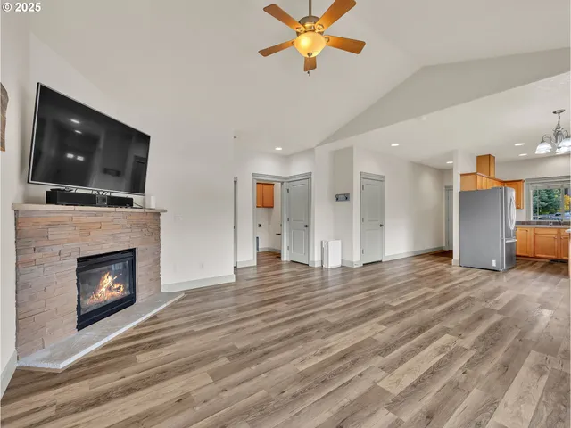 a view of empty room with wooden floor and fireplace
